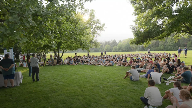 A large semi-circle of students sit 