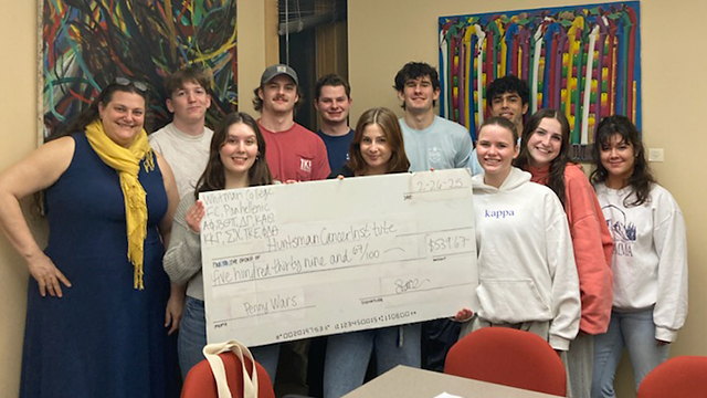 A group of people hold a giant check.