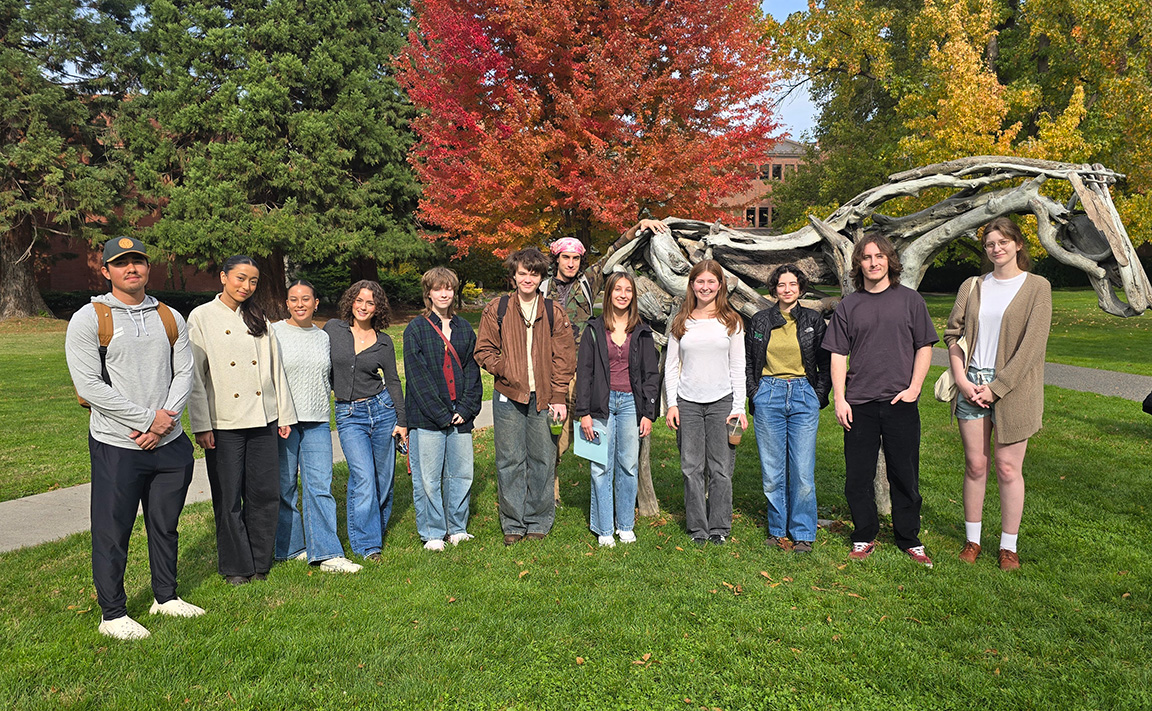 A group of students standing by the Styx sculpture on Ankeny Field