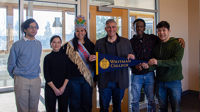 Five students stand with Congressman Michael Baumgartner, who holds a Whitman College pennant. 