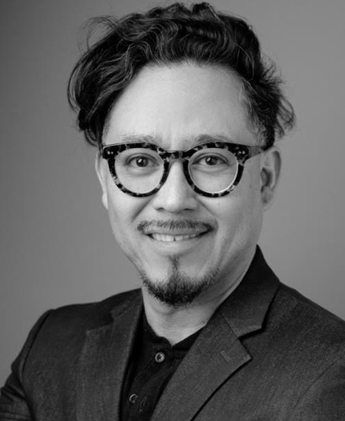 Black and white photo of Octavio Quintanilla wearing glasses.