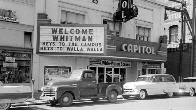 A black and white photo of the Capitol Theatre in downtown Walla Walla. The marquee reads: “Welcome Whitman. Keys to the Campus. Keys to Walla Walla.”