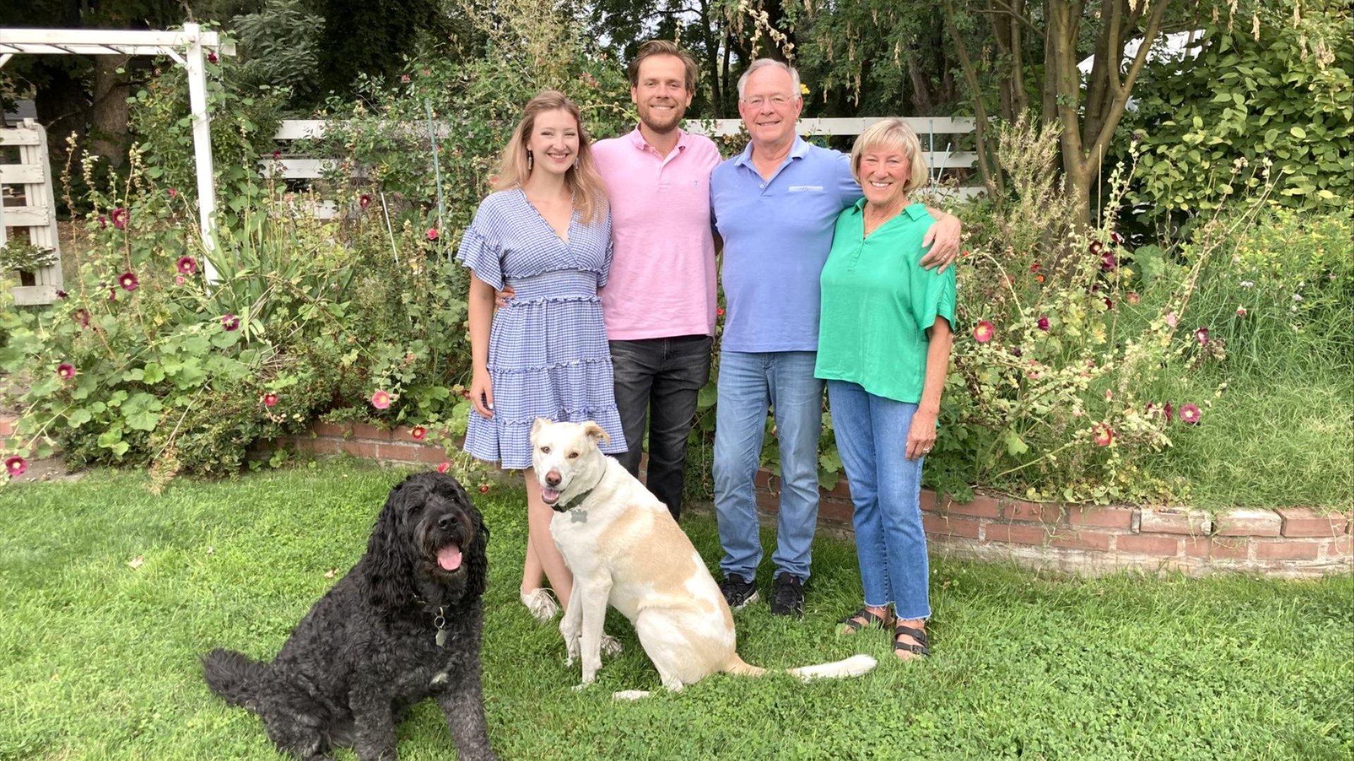 Katie, Andrew, Joe and Sarah Davis stand in a garden with two dogs