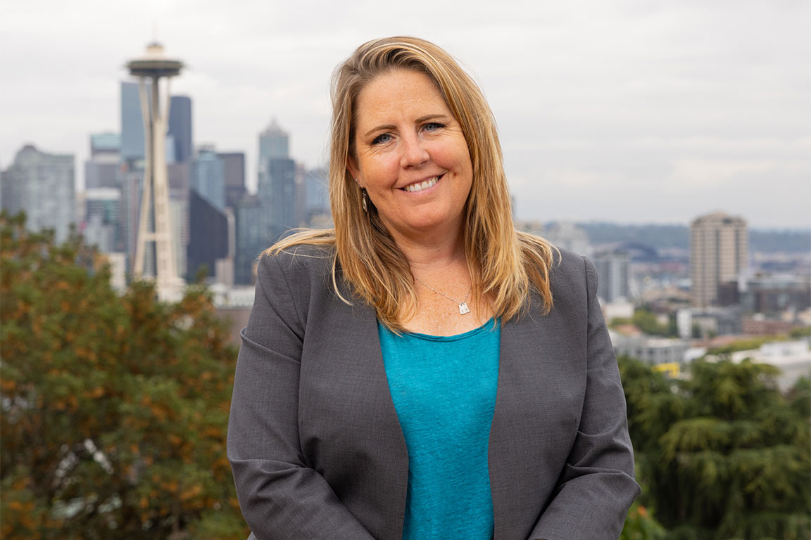 Portrait of Kira Mauseth with the Seattle skyline in the background.