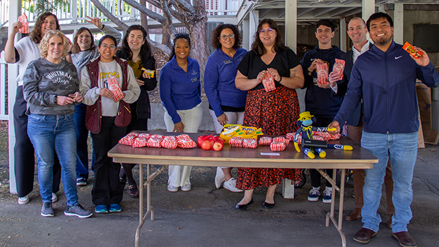 A group of Whitman employees standing by a table of treats.