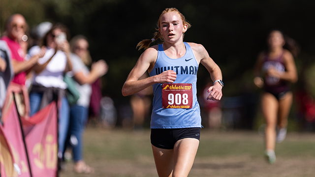 Ella Harrington running with a light blue “Whitman” shirt and a race bib with the number “908”