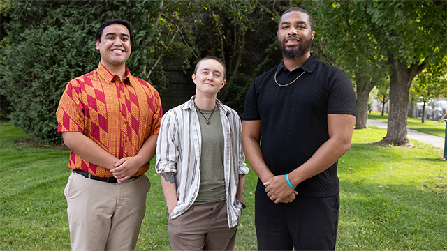 From left: Cheysen Cabuyadao-Sipe ’23, Shelby Hearn and NiQo Bullock stand together with grass and trees in the background.