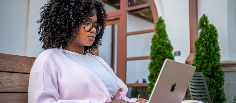Student sitting outside with laptop
