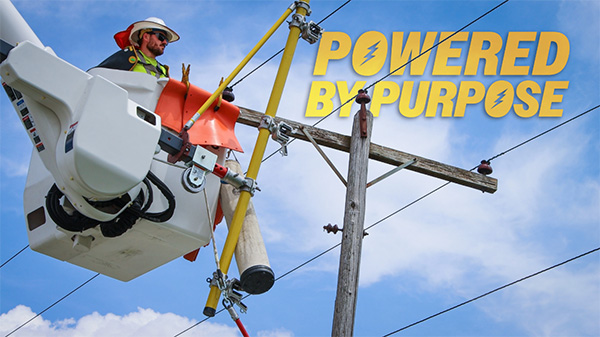Powered by purpose. - Photo: lineman standing in bucket truck, working on power line.