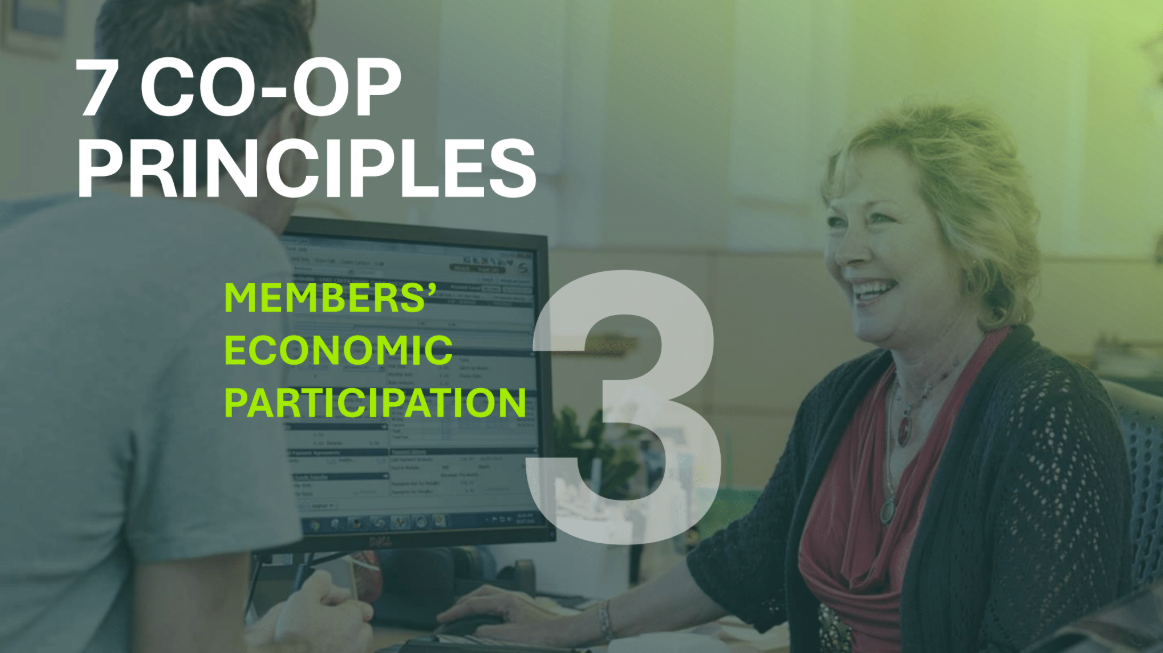 Photo of a woman working on a computer and smiling while talking to a man at a counter. Text title includes: “7 Co-op Principles” with a subtitle of “Members’ Economic Participation.”