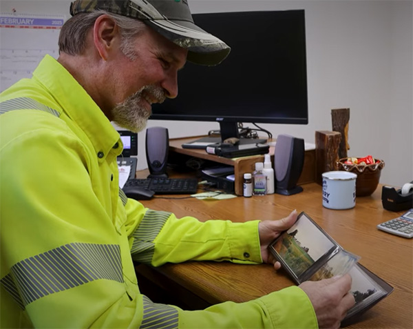 Foreman Barry Munson sitting at desk looking at pictures from the Twister set