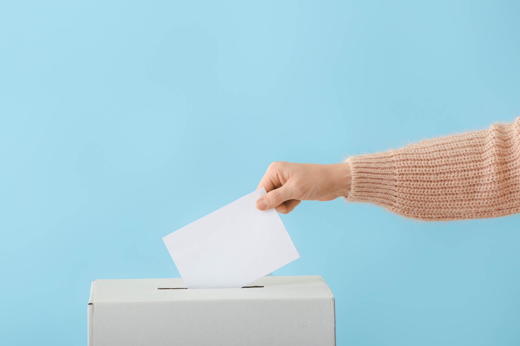 Picture of a hand putting a ballot in a box