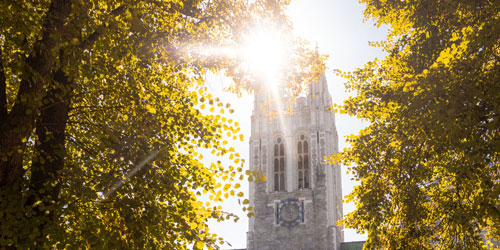 Boston College's Gasson hall through the trees in the sunshine