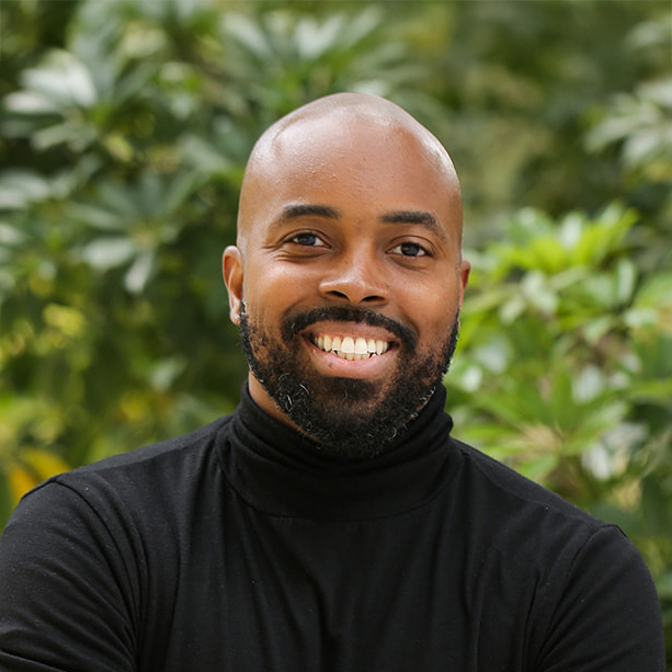Earl Edwards in black turtleneck against leafy background