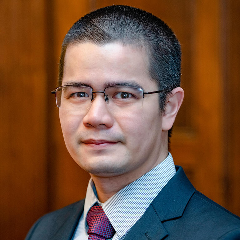 Jose Eos Trinidad in front of a orange backdrop