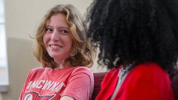 first generation student smiling while talking to woman