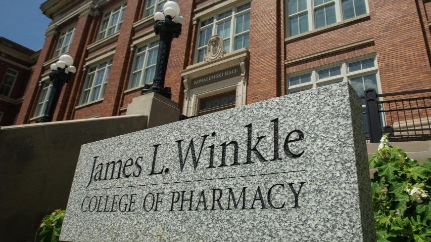 James L. Winkle College of Pharmacy building with a stone sign in the foreground.