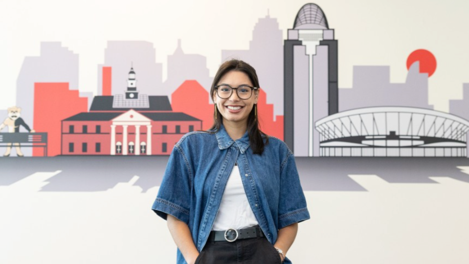 Abigail Miklowski standing in front of a mural