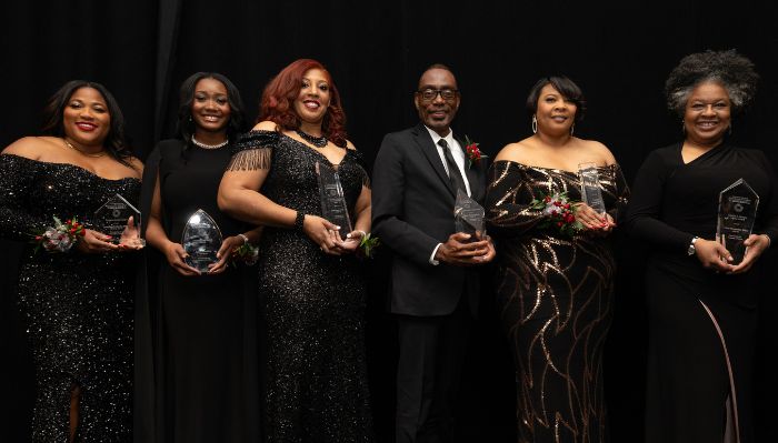 Onyx and Ruby Gala honorees stand and smile holding their awards.