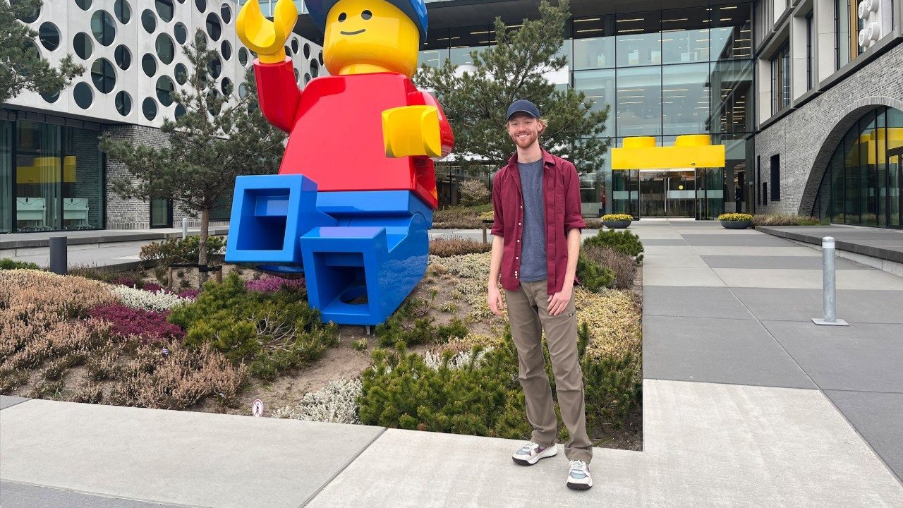 DAAP student Adam Wolshire standing in front of a giant Lego man. 