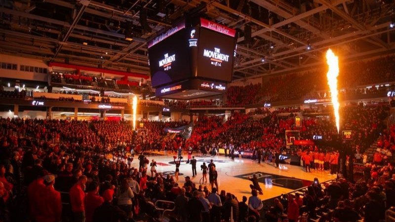 Inside of Fifth Third Arena with fans, flames, and scoreboard reading The Movement.