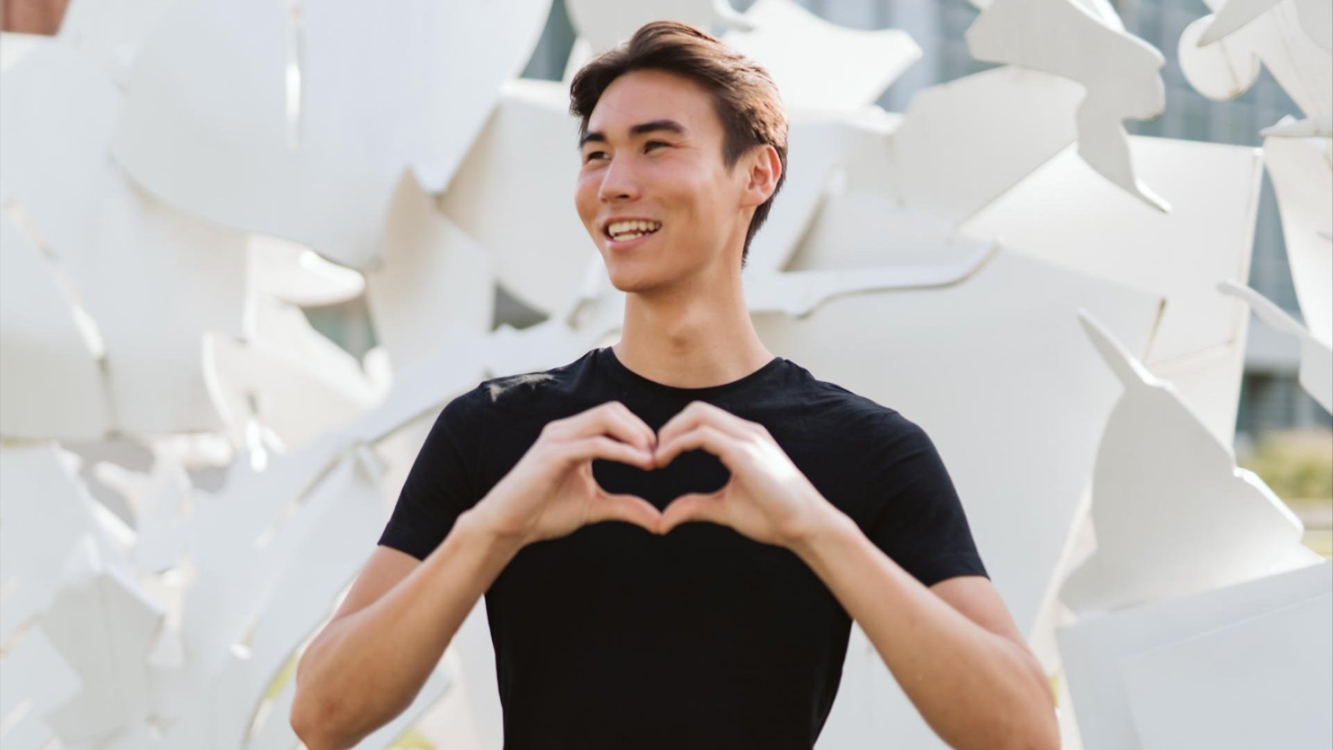 student making a heart with his hands