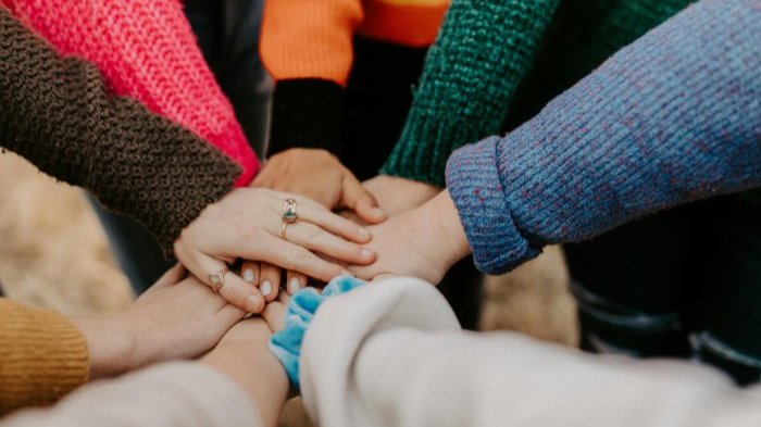 A group of people placing their hands together in a circle.