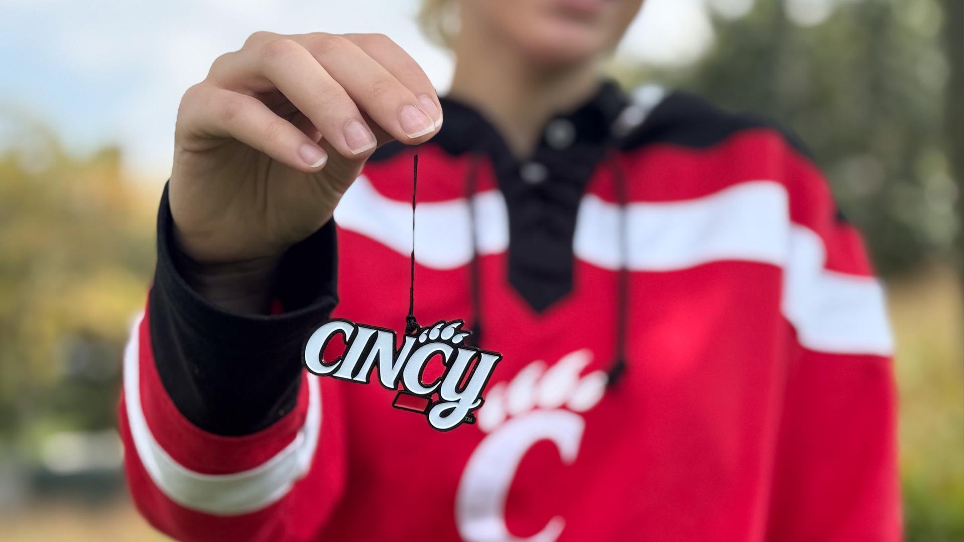 Student holding limited edition Cincy ornament for UC Giving Tuesday