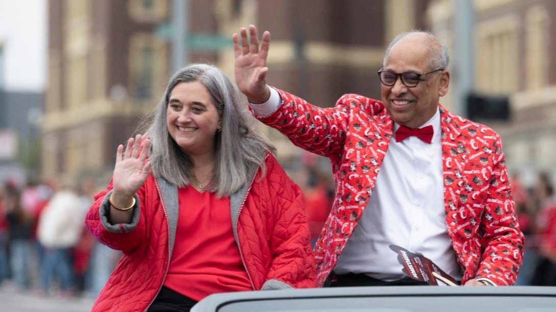 Dr. Jennifer Pinto and UC President Neville Pinto riding in a car at the Homecoming parade