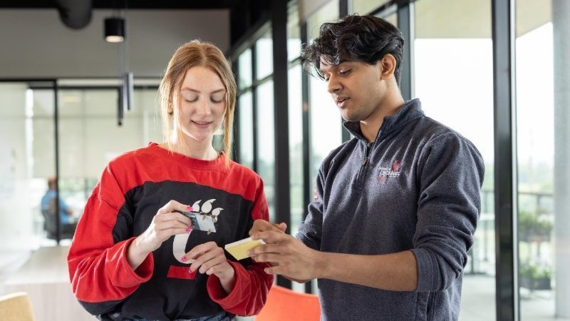 Two students working together in a bright indoor space