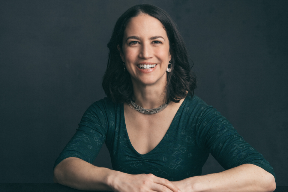 An image of best-selling author Catherine Price smiling in front of a grey background.