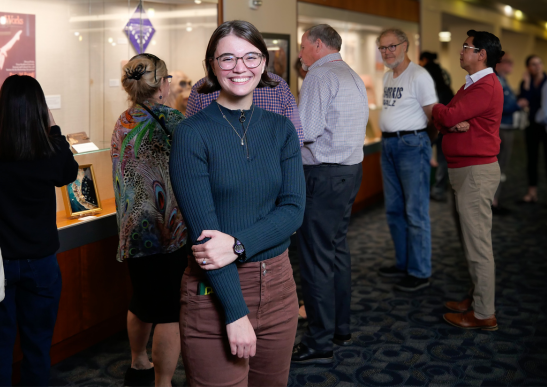 Image of graduate student Claire Keck standing in front of her exhibit at MD Anderson library 