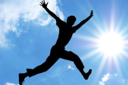 A silhouette of a man jumping in the air.