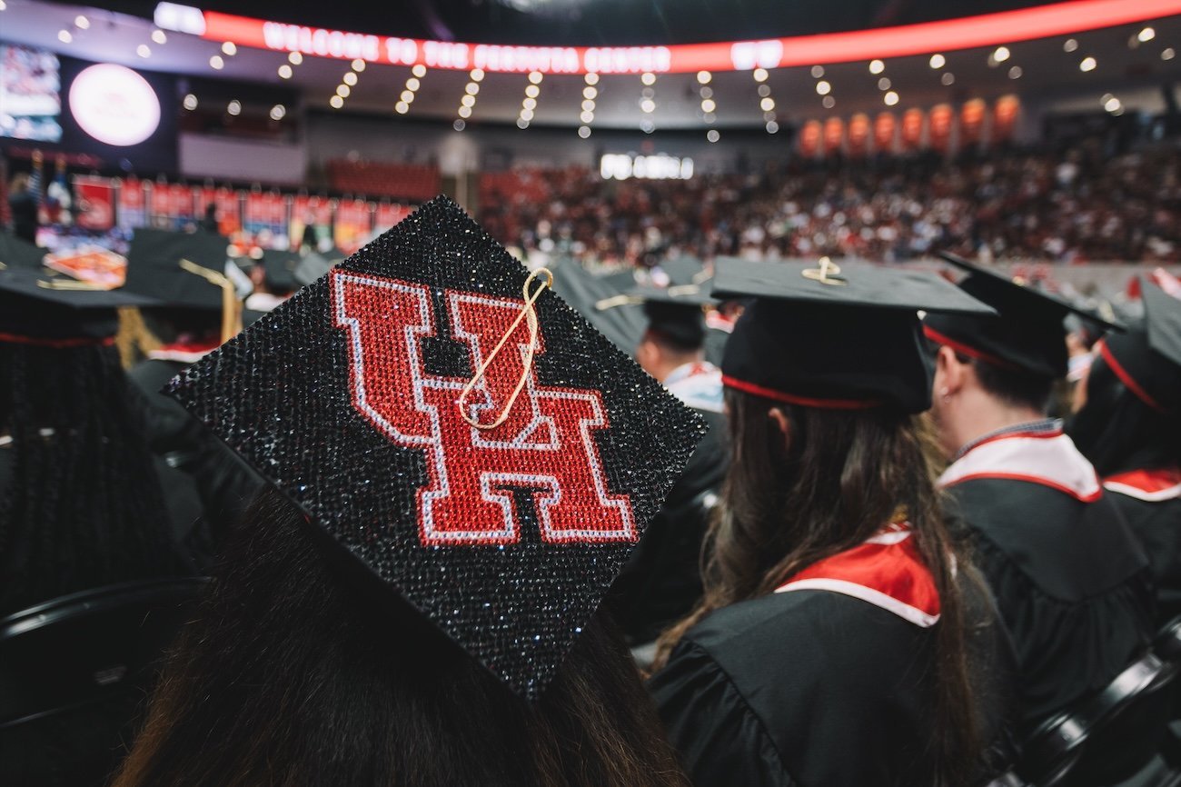 Image of a rhinestoned UH cap at a graduation.