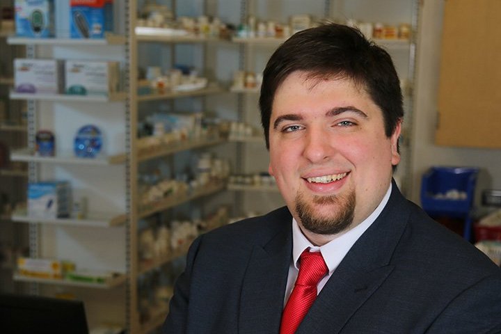 Associate Professor Douglas Thornton in a suit with red tie smiling