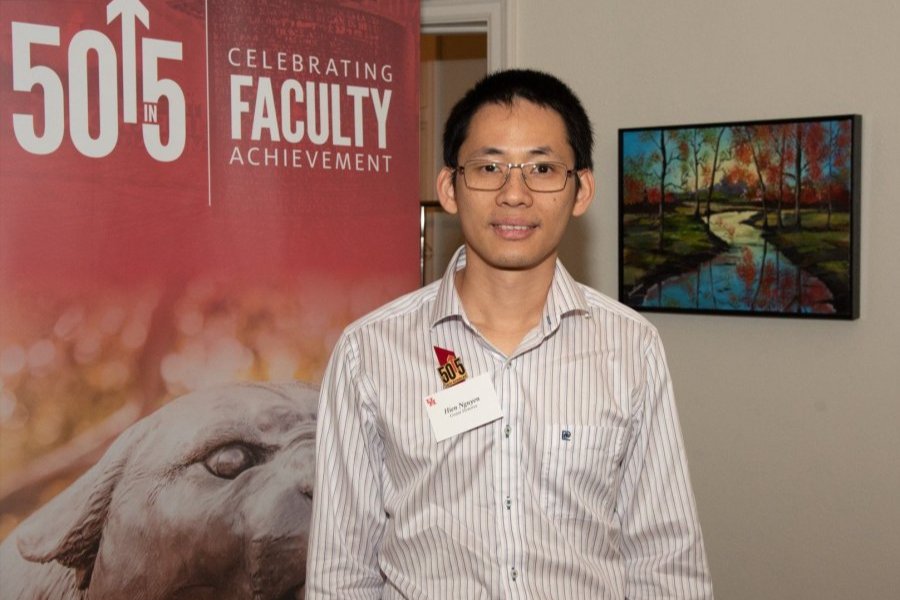 Hien Van Nguyen in button up t shirt smiling at camera