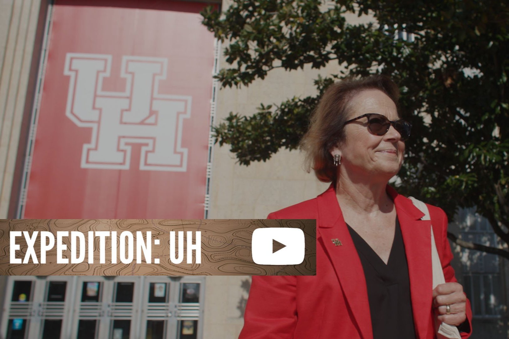 Thumbnail of Expedition: UH. It shows Diane Z. Chase walking in front of the Ezekiel W. Cullen building.