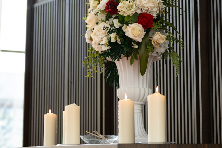 Image of floral arrangement with white candles surrounding it
