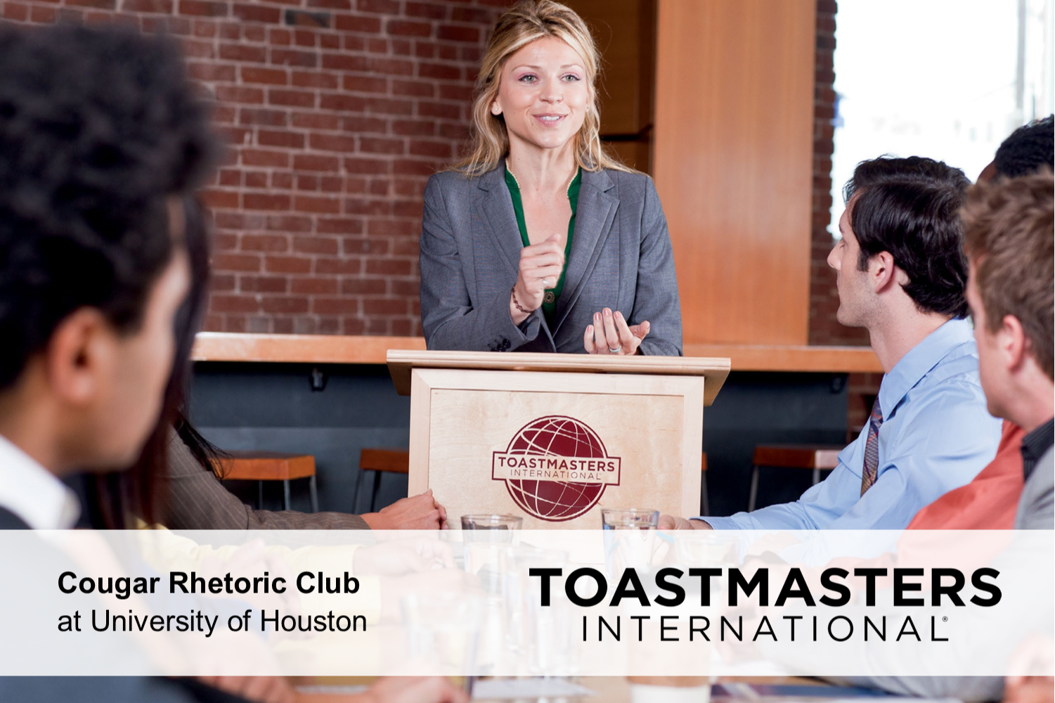 A woman standing at a podium with the text Toastmasters International on the bottom.