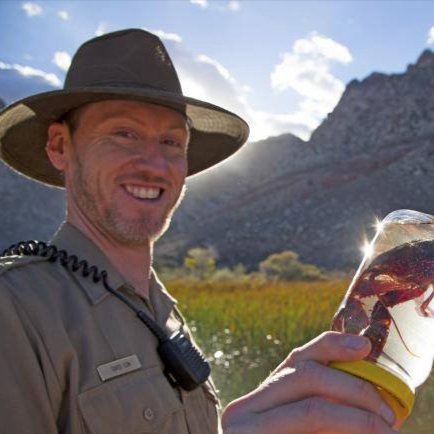 Nevada State Parks Ranger smiling and holding specimen in a glass jar