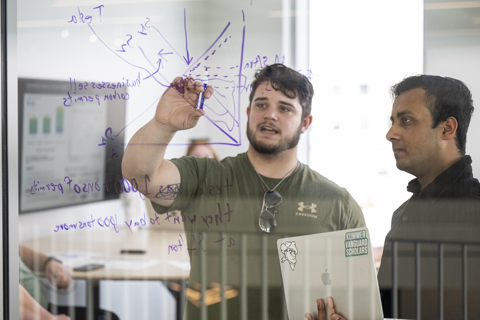Two students at S&T marking on a whiteboard in a study hall at the Innovation Lab.
