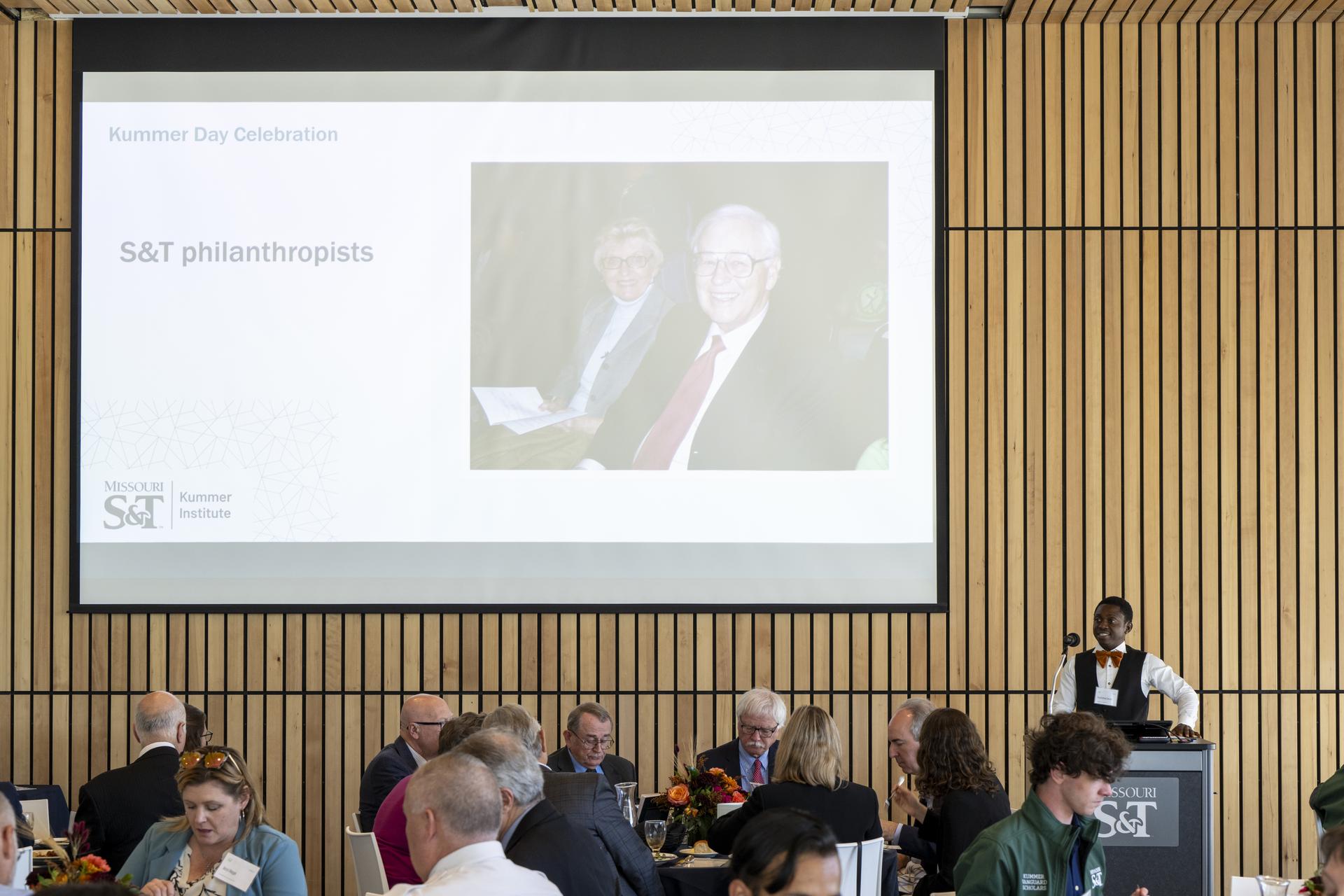 A group of people sitting in front of a large screen while a speaker presents during Kummer Day at S&T.