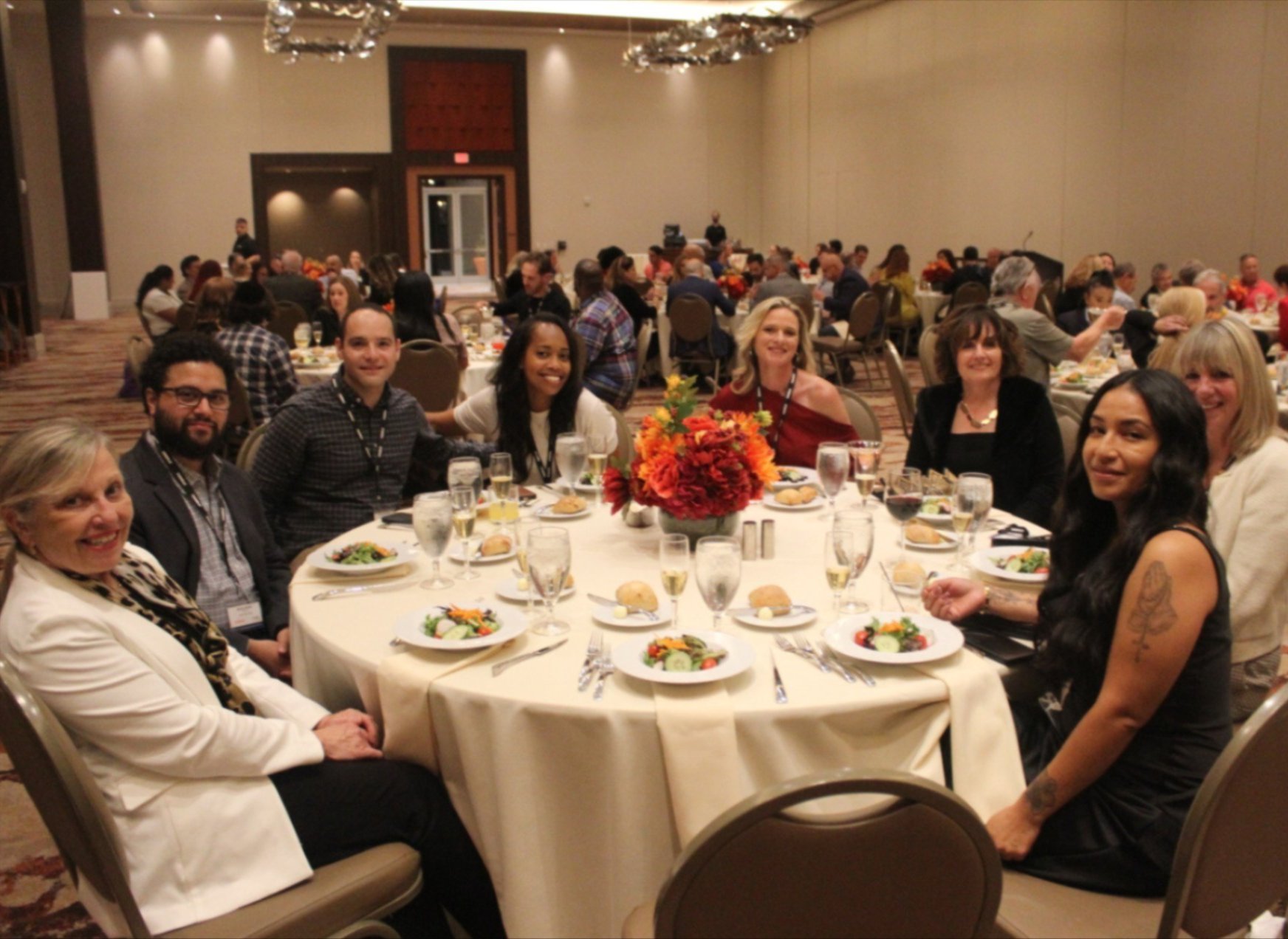 a group of people sitting at a table in a banquet hall at Curalta Educational Conference