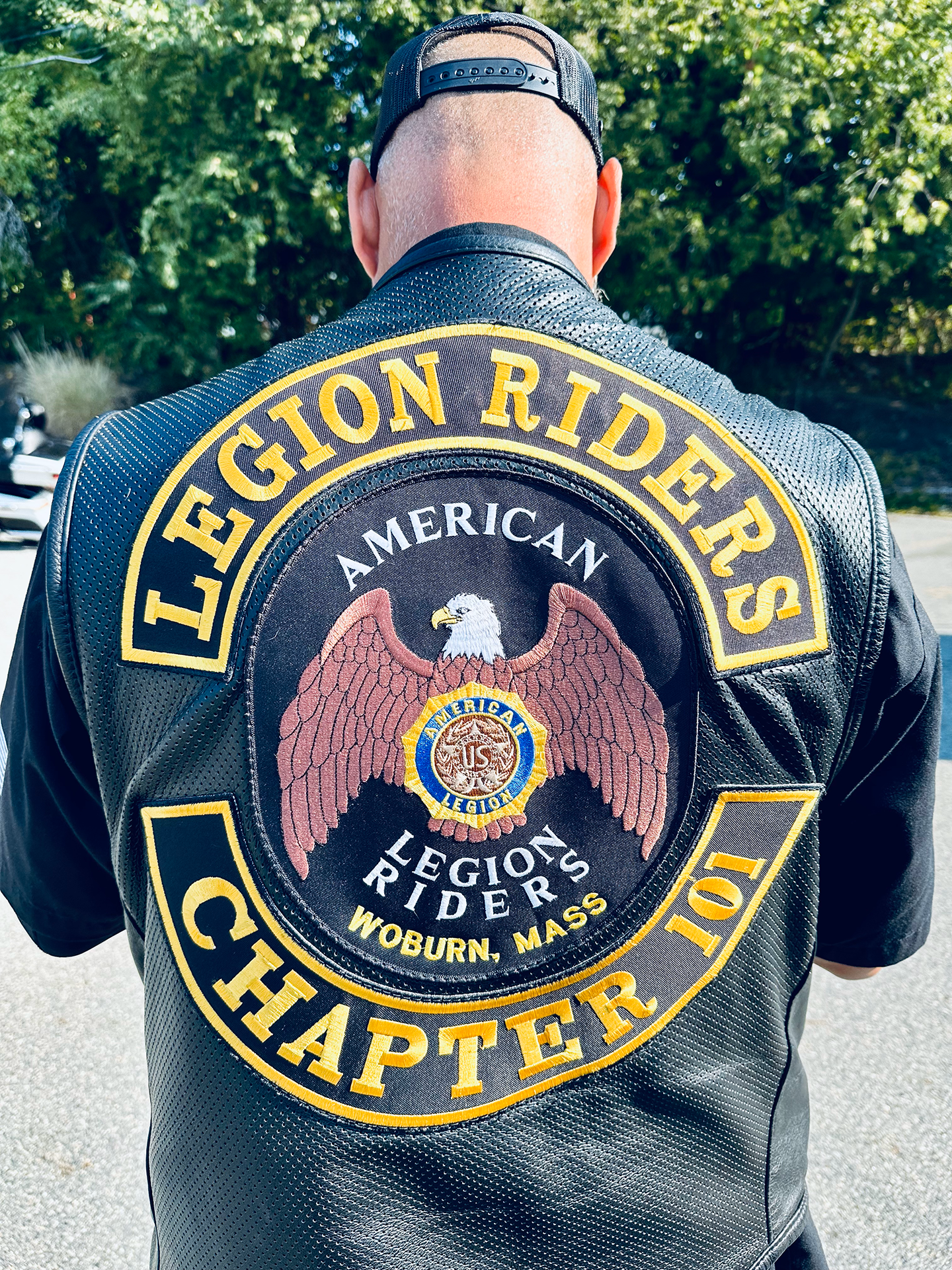 a back of a man wearing a black leather jacket with a large eagle on it