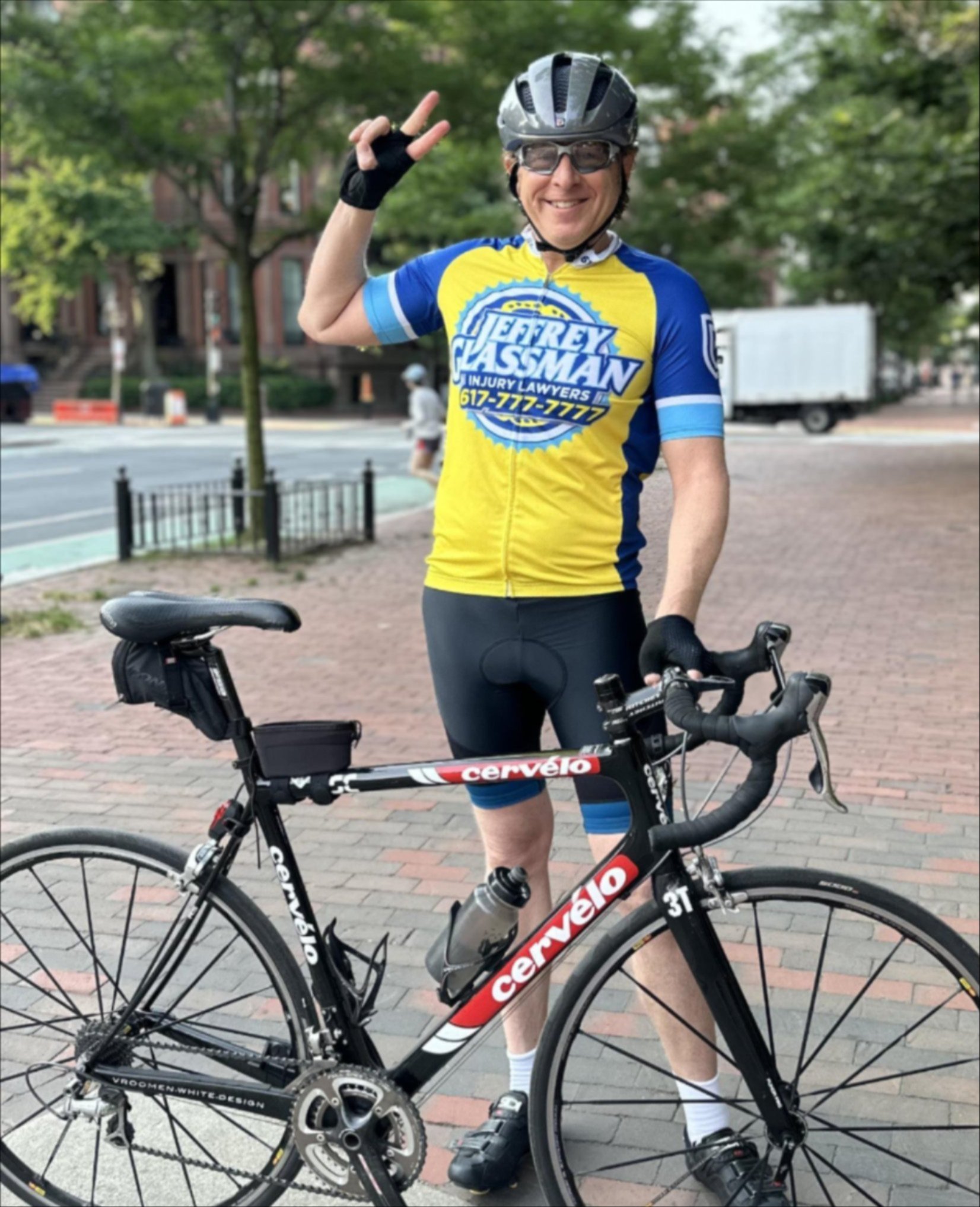 a man in a bicycle helmet and helmet holding up a peace sign