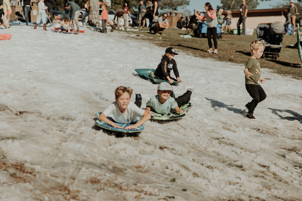 Kids sledding down the snow hill at Snow Day 2025