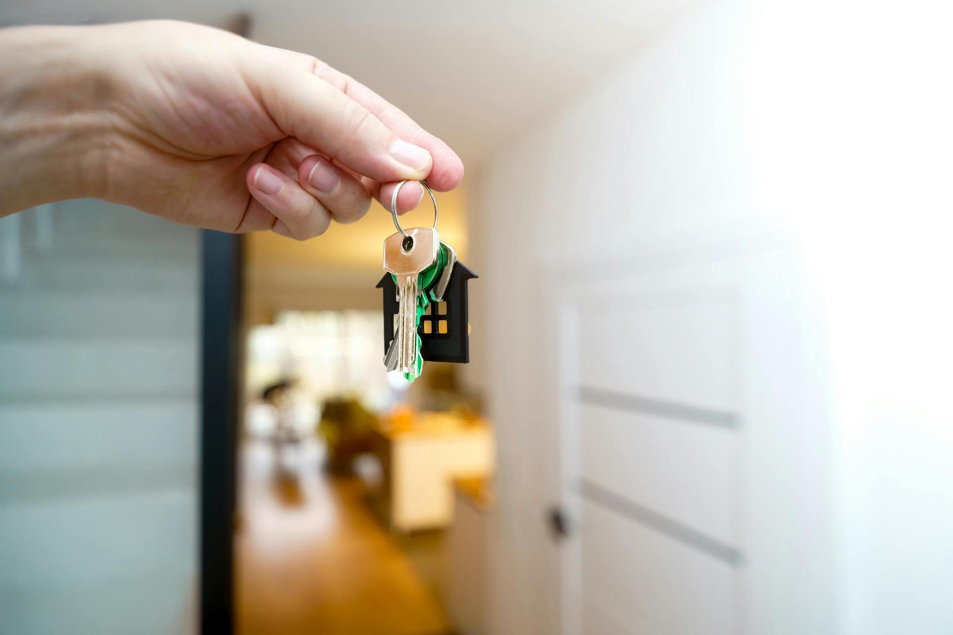 Hands holding house keys, symbolizing a new home purchase.