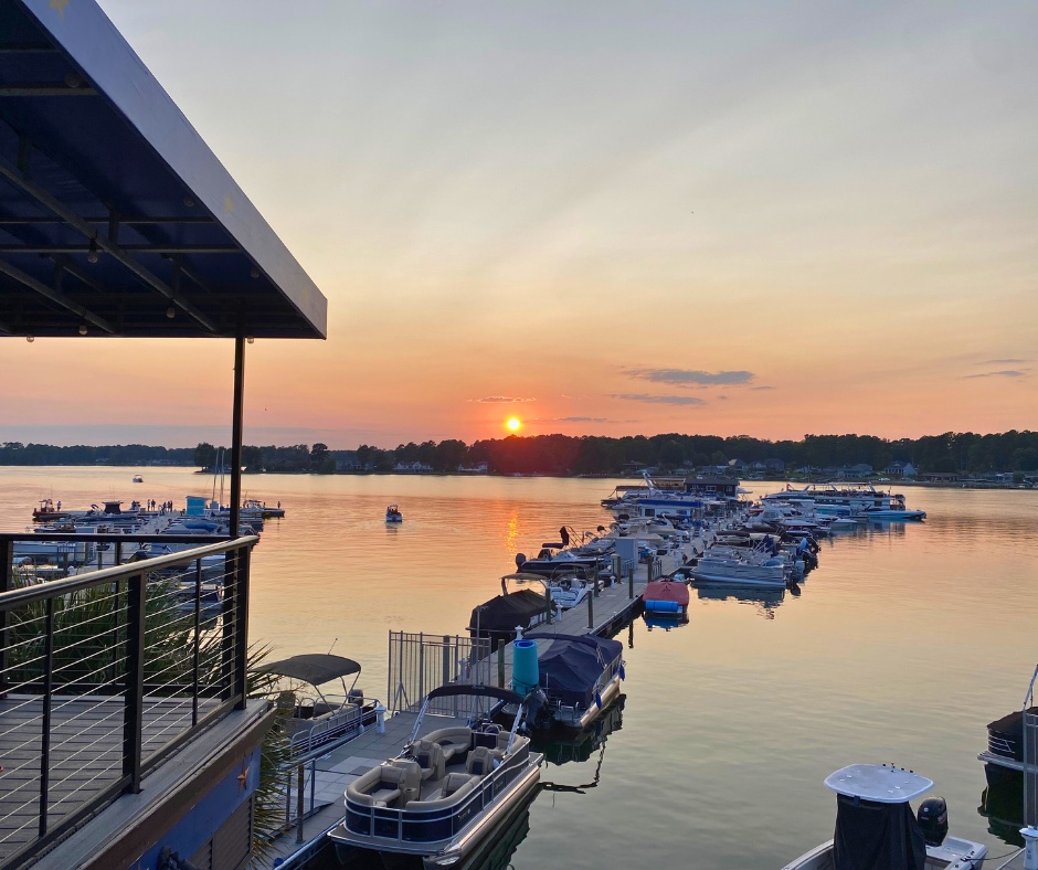 Outdoor dining at Lake Murray waterfront restaurant with sunset over the water in the background