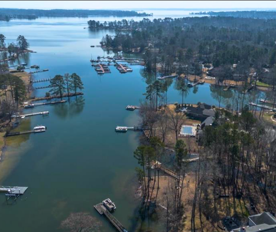 Scenic view of Lake Murray featuring a waterfront neighborhood with private docks and boats along the shoreline, highlighting lakefront living in Chapin, SC.- realtorlakemurraysc.com