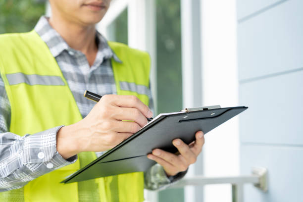 Utah home inspector with clipboard reviewing a property during the inspection process for a first time homebuyer
